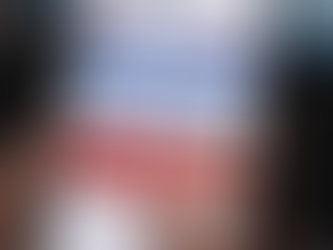 A person holding a smartphone displaying the OFSS Bihar website with “Bihar Class 11 Admission 2026” and an “Apply Online for Intermediate Admission 2026–28” button visible on the screen, with a blurred laptop in the background.