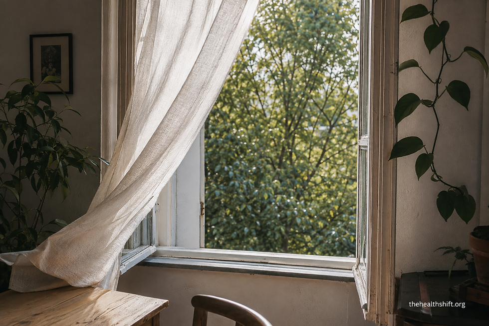 Open raam met een gordijn dat zachtjes beweegt in de bries en frisse lucht binnenlaat in een kamer vol planten.
