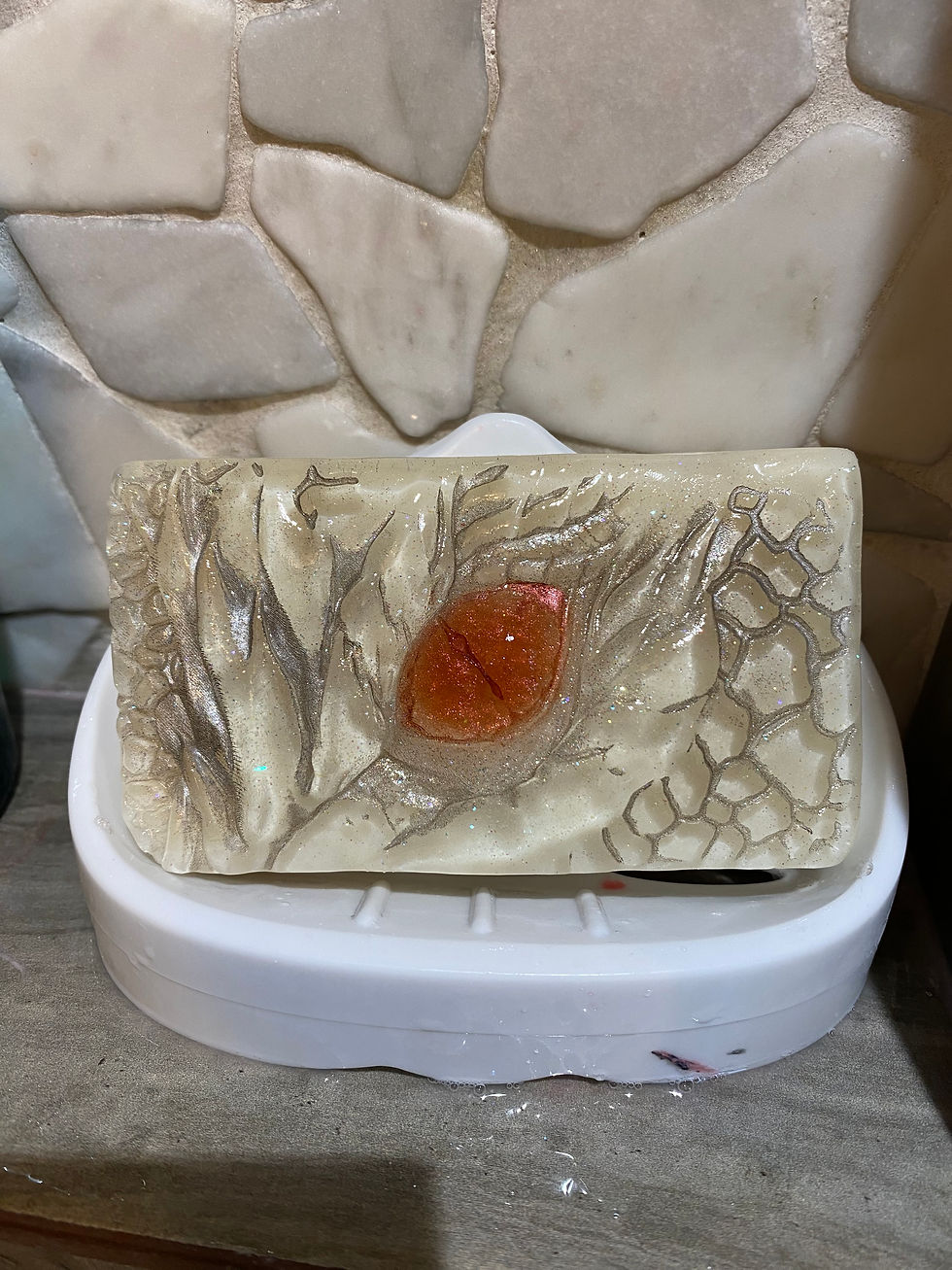 Dragon eye soap bar with shimmering scales, resting in a white soap dish against a stone tile background.