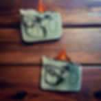 Two green and black swirl soaps stamped with 'OwO', each topped with a red and orange flame-shaped embed, displayed on a wood