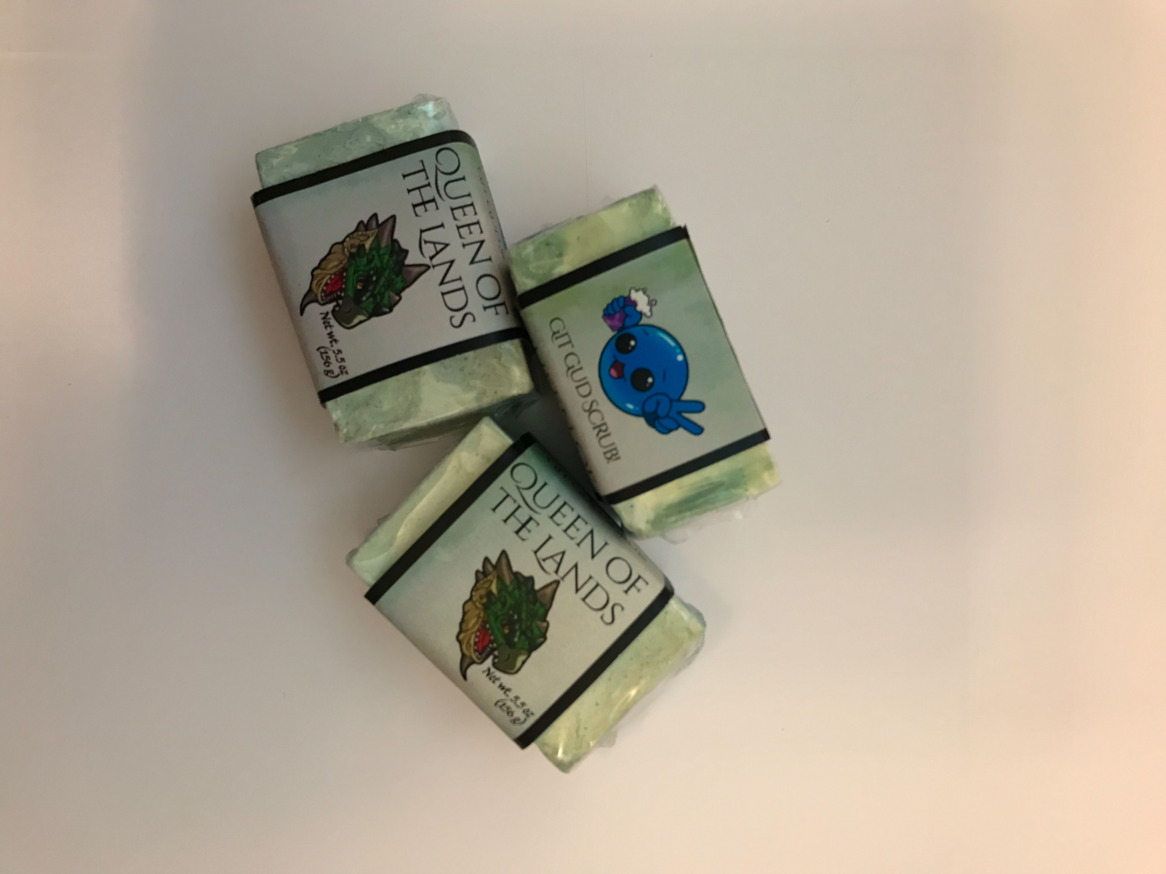 Three labeled handmade soap bars with green marbled design arranged together on a white background