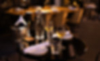 Outdoor dining table at an illuminated restaurant at night
