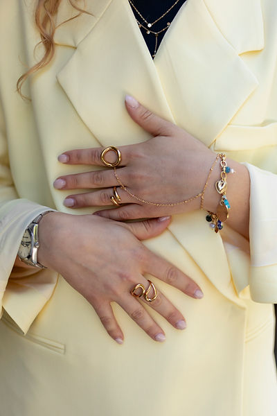 Vrouwelijke handen met gouden ringen en armband