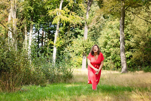 Florette in de natuur met roze jurk. Lacht.