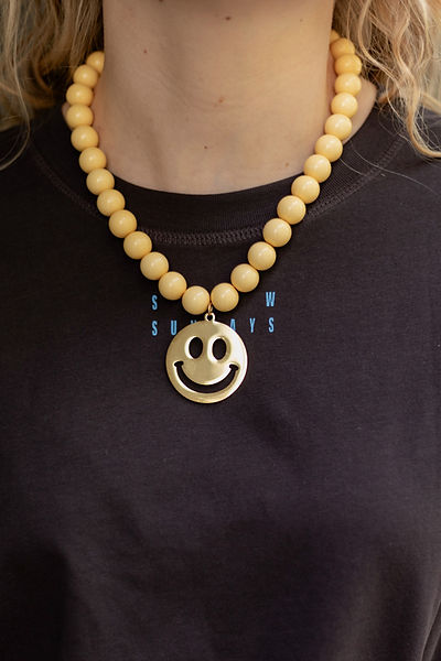 Gele kralenketting met smiley hanger