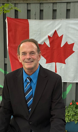 Michael Bastian standing in Ward 6, Mississauga, with the Canadian flag