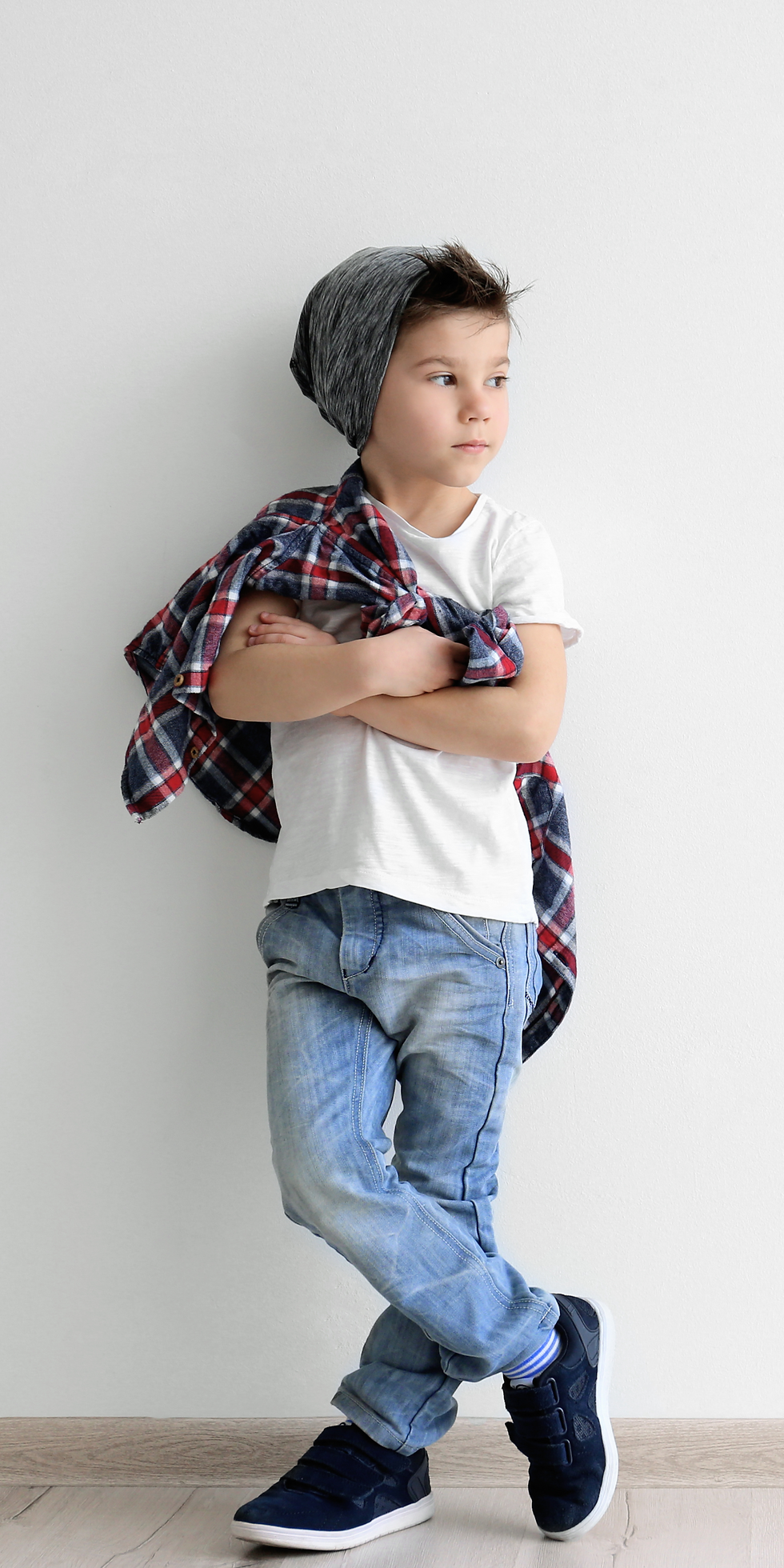 Grand enfant stylé devant un mur