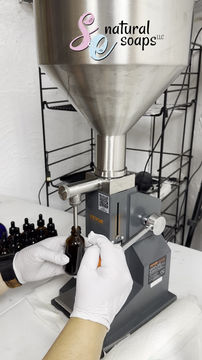 Pouring coffee bean oil into brown glass bottles with a machine