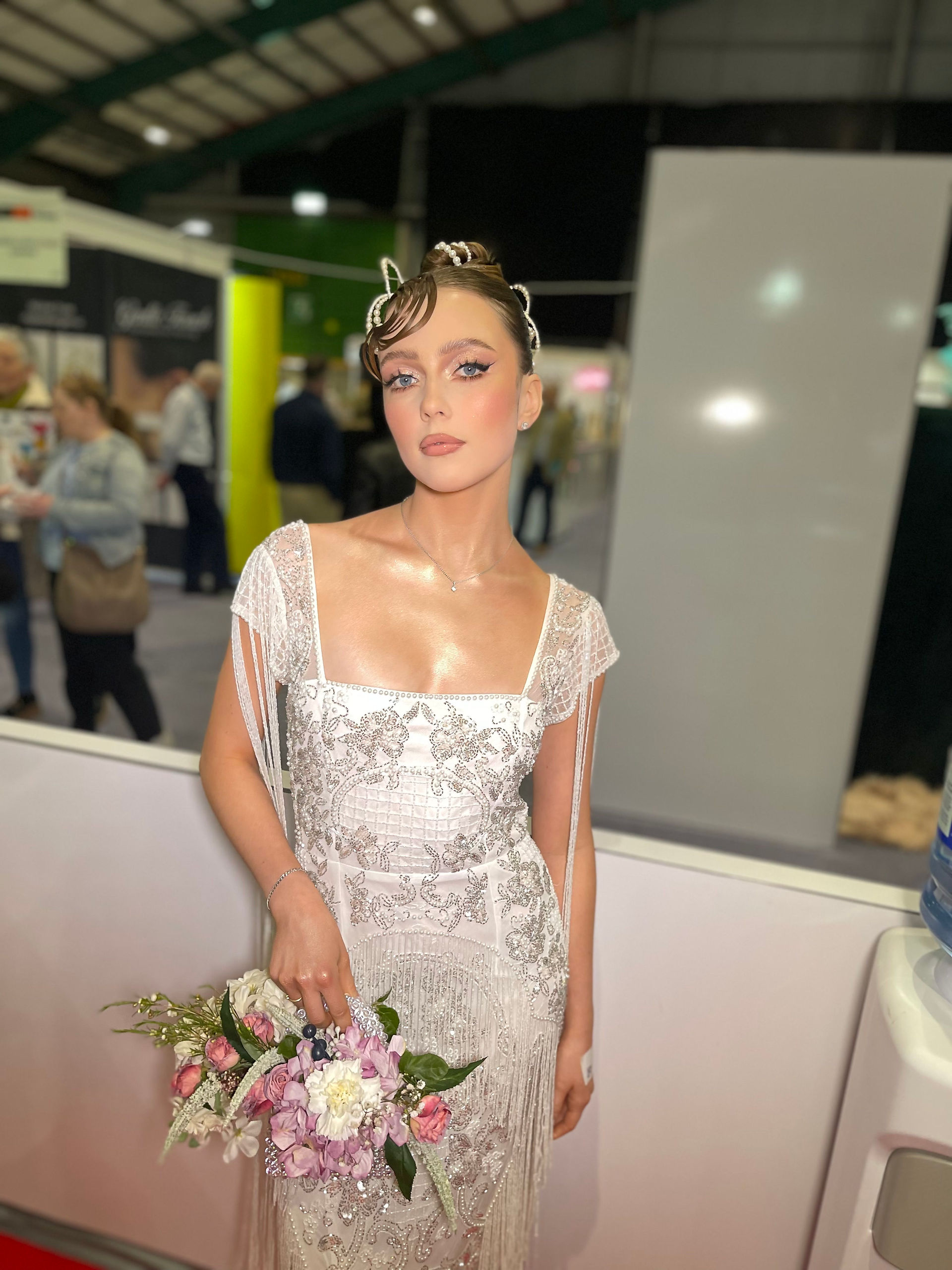 Bridal stylist providing both hair and makeup, perfecting a complete wedding look with polished finishing touches.