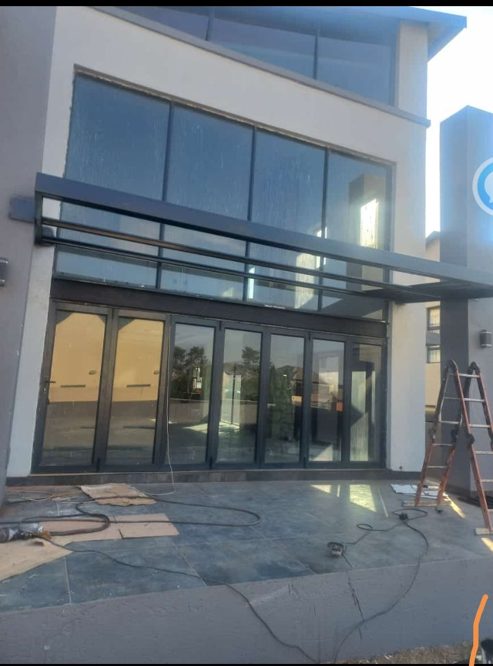 Modern building with large aluminium folding doors, fixed windows and standard windows.