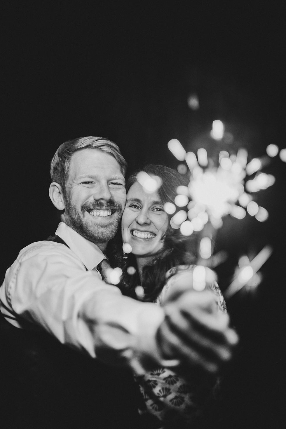 Couple holds sparkler in hands