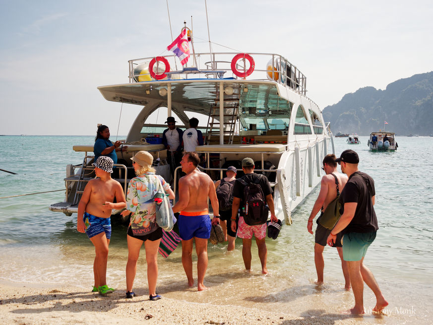 Tourists gathered at the back of a boat on a beach near Phuket in Thailand.