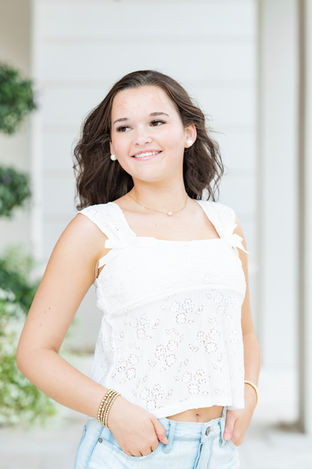 Meredith posing near greenery during her Fairhope senior portrait session.