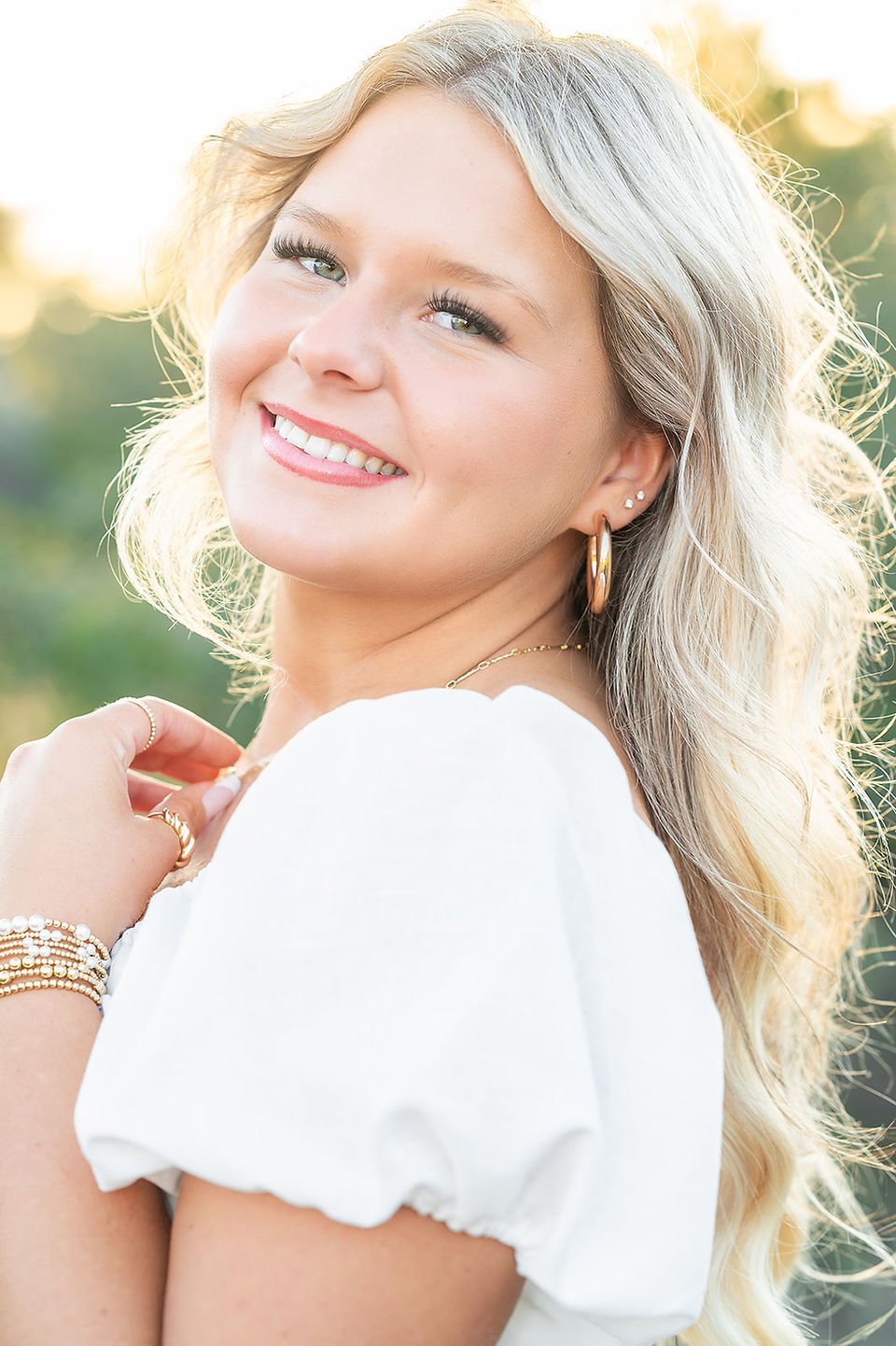 High school senior standing on a Gulf Coast beach at sunset during a senior portrait session.