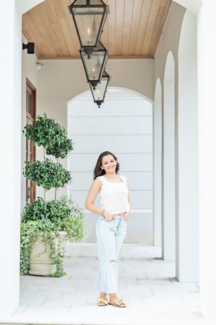 Meredith posing near greenery during her Fairhope senior portrait session.