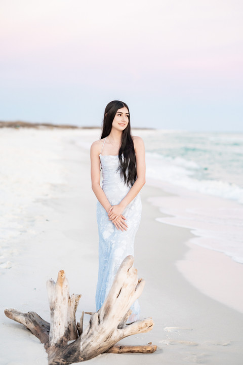 Senior girl standing along the shoreline during a beach Pensacola senior portrait session.