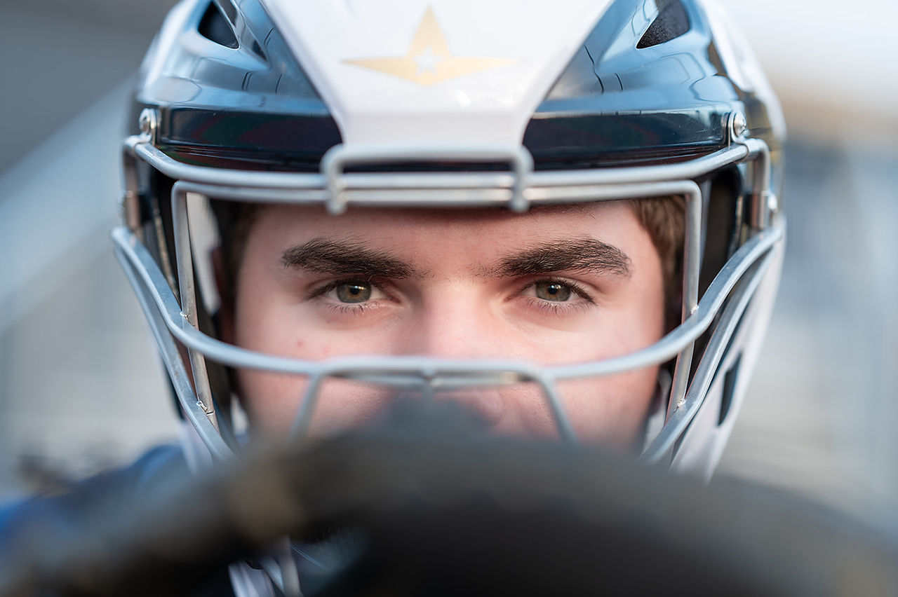 High school senior wearing full football gear during a personalized senior portrait session.