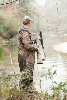 Duck hunters calling and watching the sky during early morning hunt
