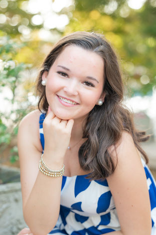 Meredith’s downtown Fairhope senior portraits showcasing greenery and historic architecture.