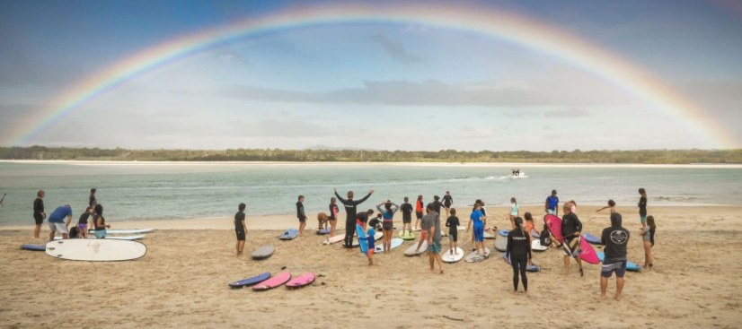 Sunset over group of students on Noosa West Beach as Surfdancer holds lessons for school children