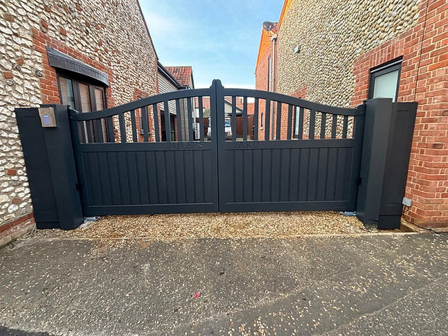 Dark grey arched timber driveway gate with matching posts