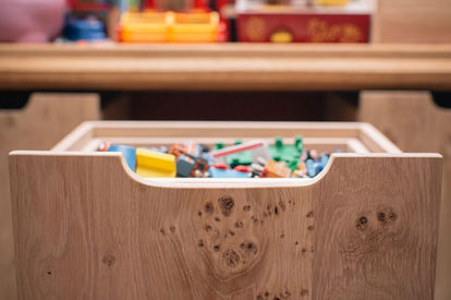 Pull-out wooden toy storage drawer filled with colourful blocks