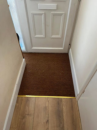 Freshly installed brown textured carpet inside a home doorway