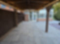 Timber wooden pergola over a stone paved patio in a residential garden