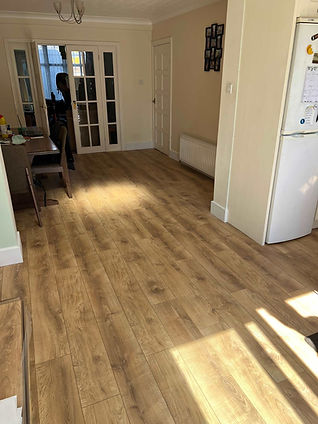 Light oak style laminate wood flooring laid in an empty white room