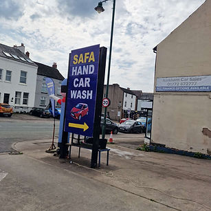 Hand car wash entrance with roadside sign