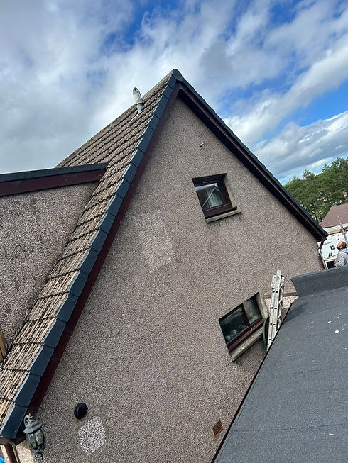 The image shows a roughcast (dash-render) house gable wall featuring a distinct patch repair or test-cleaning square near the upper window