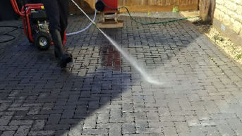High pressure jet washing of dark driveway paving blocks