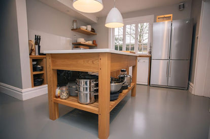 Spacious kitchen featuring a bespoke oak island unit with open shelves