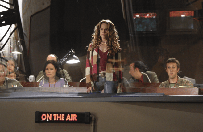 A still from Little Black Book, Holly Hunter behind a broadcasting station that is on the air. 