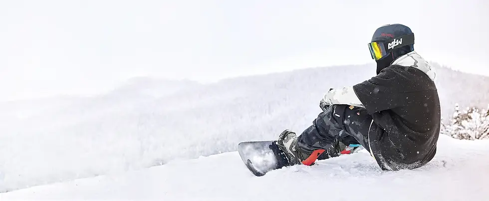 Eye-level view of a snowboard helmet resting on snow-covered ground