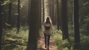 Woman walking on a sunlit forest path, surrounded by tall trees and lush ferns. She's wearing a backpack, creating a serene, adventurous mood.