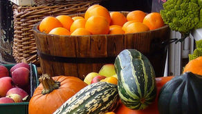 Assorted fruits and squashes in baskets; apples, oranges, pumpkins.