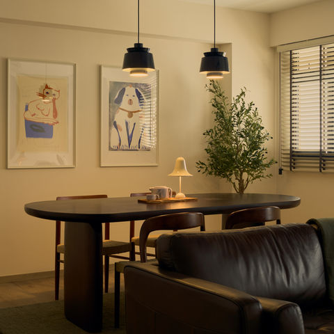 a living room with a table and chairs and a lamp