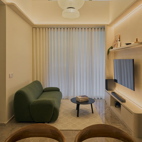 a living room with a green couch and a flat screen tv