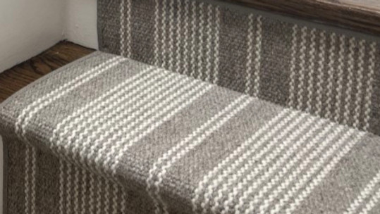 Close up of a striped wool stair runner showing its expert installaion by our Boston carpet installation team.