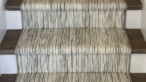 Hollywood style stair runner wrapped tightly around each step for a tailored upholstered look on a traditional staircase