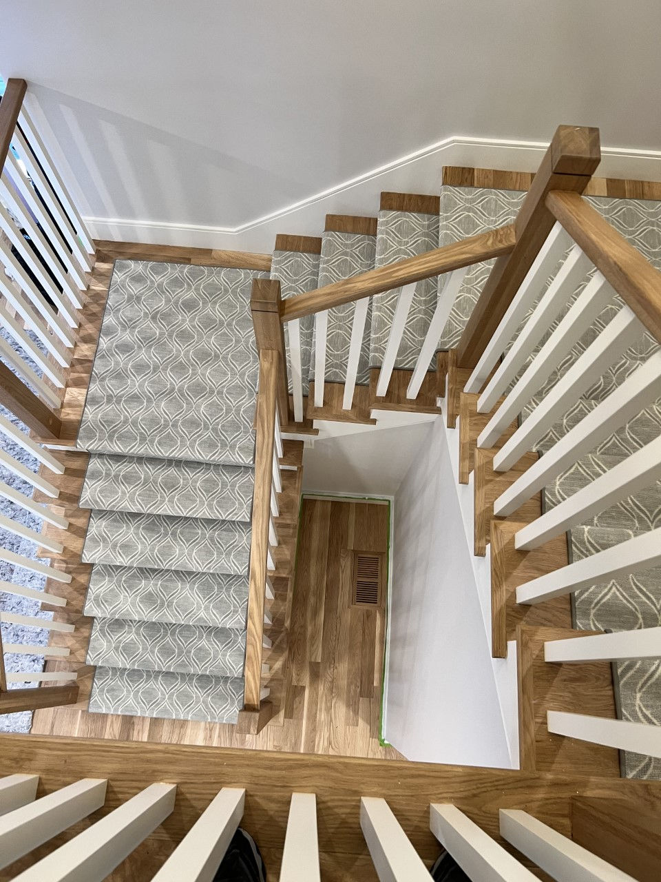 Custom stair runner installed on a staircase with a landing and turn, showing precise fitting and seamless transitions