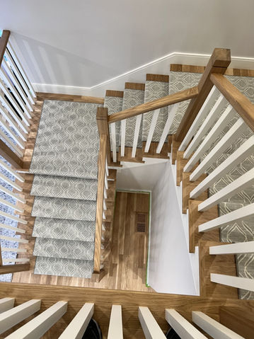 Modern abstract patterned carpet installed on a winding staircase in a Boston multi-level home.