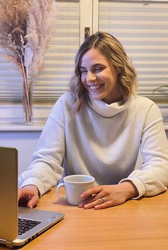 Dietitian on a zoom call, smiling with coffee in her hand.