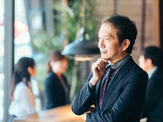 顎を触りながら考える男性