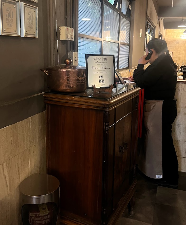 At the "Hostess Stand", right inside the front door of Nicos