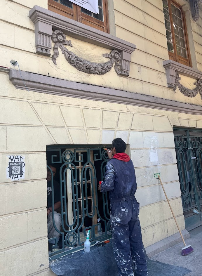 A shot of a maintenance man, touching up the paint on the Art Déco wrought iron window security screen of one of the beautiful buildings lining Avenida Álvaro Obregón.