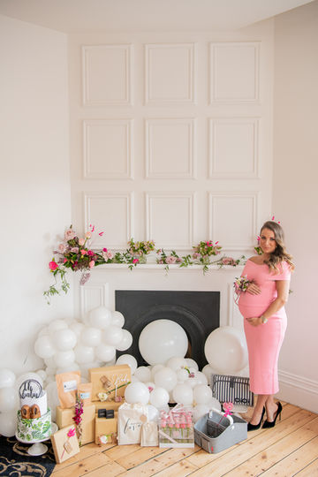 baby shower flowers decorating a fire place and small table flowers with balloons