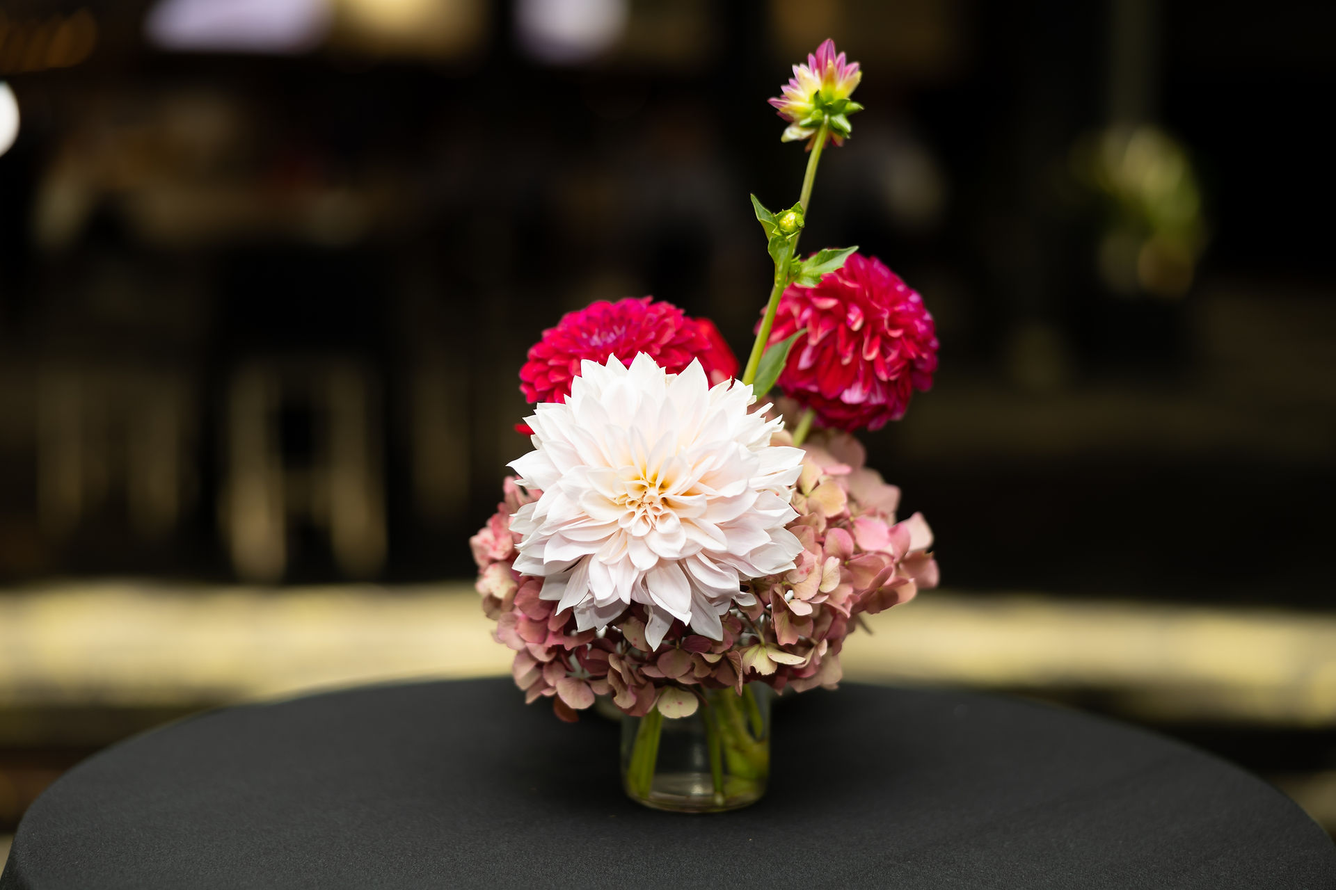 beautiful cocktail table flowers in shades of pink featuring dahlias, hydrangea and disbud 