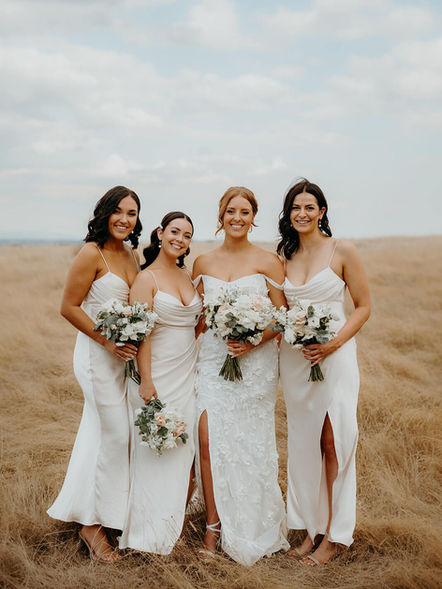 Bride and bridesmaids holding classical white and green wedding bouquets